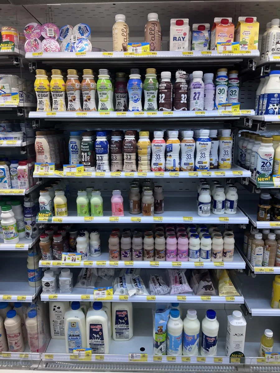 Protein drink shelf in a Thai 7-Eleven: high-protein milks with 20 to 33 g protein per bottle