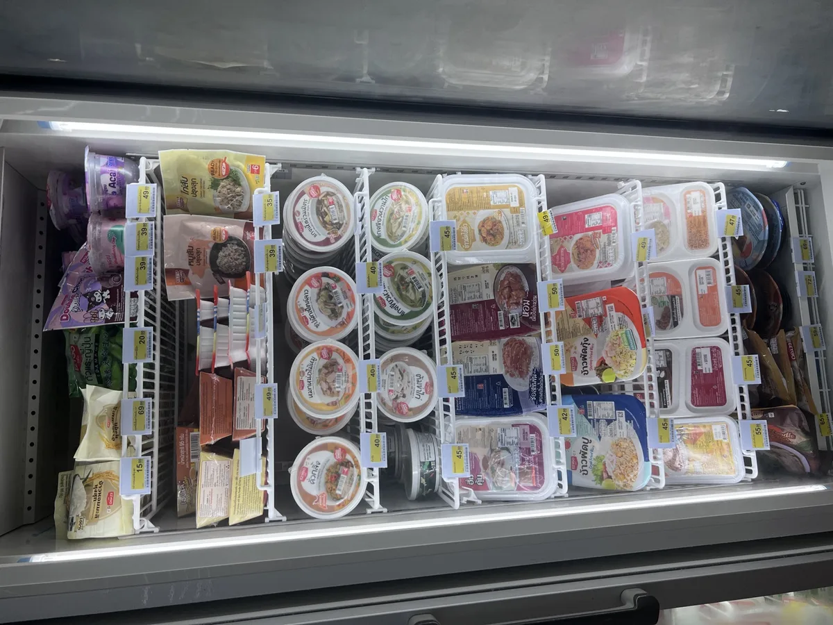 Ready-meal fridge in a Thai 7-Eleven with pre-portioned rice dishes and curries